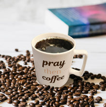 Load image into Gallery viewer, PRAY THEN COFFEE front side of the mug with coffee beans scattered around and book placed in the background
